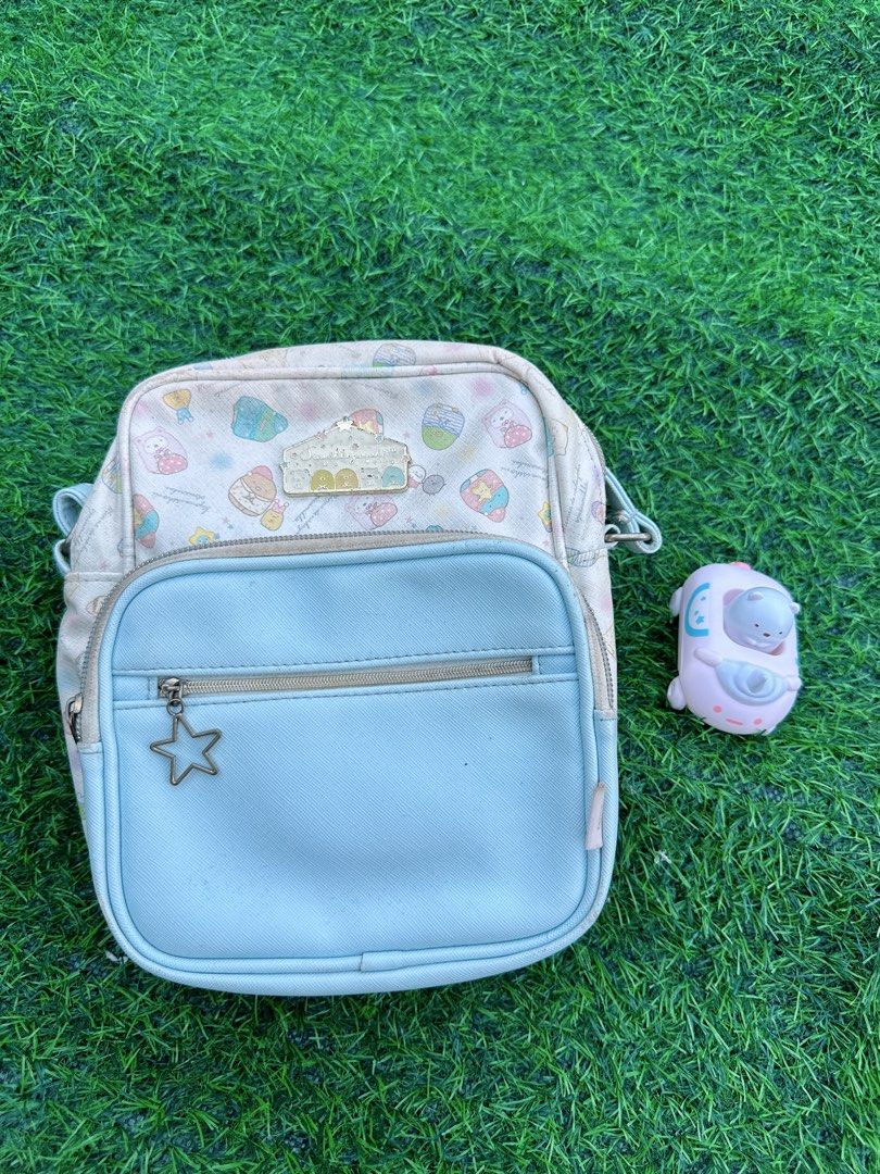 Sumikkogurashi Crossbody Bag Pastel Characters (Category: Cross-body Bags) located in Manila. Submitted by ronoarabbit.ph (Listing ID 1466438434, Image 1). Description: ❗️‼️Bag has signs of usage and flaws (see all photos) that’s why so cheap price. But still usable and for collector’s purposes.❗️‼️ - Authentic Sumikkogurashi crossbody bag with all-over pastel character prints - Light blue front pocket equipped with a cute star zipper pull - Adju