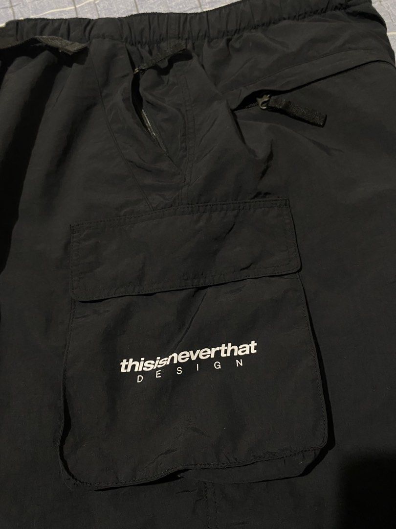 thisisneverthat Black Cargo Shorts with Belt (Category: Shorts) located in Escalante. Submitted by relicofthenorth.082630 (Listing ID 1466466526, Image 3). Description: - Brand: thisisneverthat - Color: Black - Style: Utility cargo shorts - Waist: Built-in adjustable belt with buckle closure - Pockets: Multiple pockets including side cargo pocket with white brand text print and back pocket with button snap - Details: Branded fabric label on back 