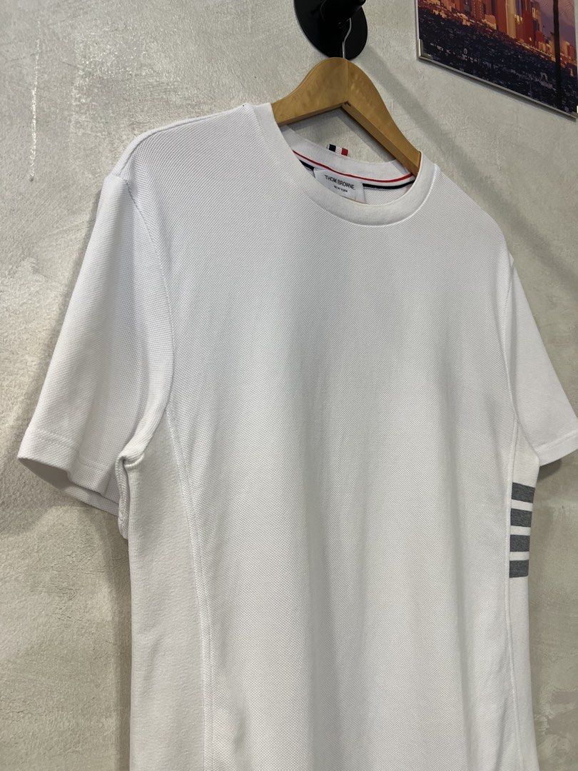 Thom Browne Classic Pique 4-Bar Tee (Category: Formal Shirts) located in Manila. Submitted by -handpick- (Listing ID 1466372640, Image 3). Description: Thom Browne Classic Pique 4-Bar Tee Features a crew neckline, signature grey 4-Bar stripes on the left side, and a signature tricolor grosgrain loop tab at the back neck. Size : 0 Dimensions : Length : 27 inches Width : 20 inches Shoulder : 18.5 inches Sleeve : 9.5 inches Sign of wear in good cond