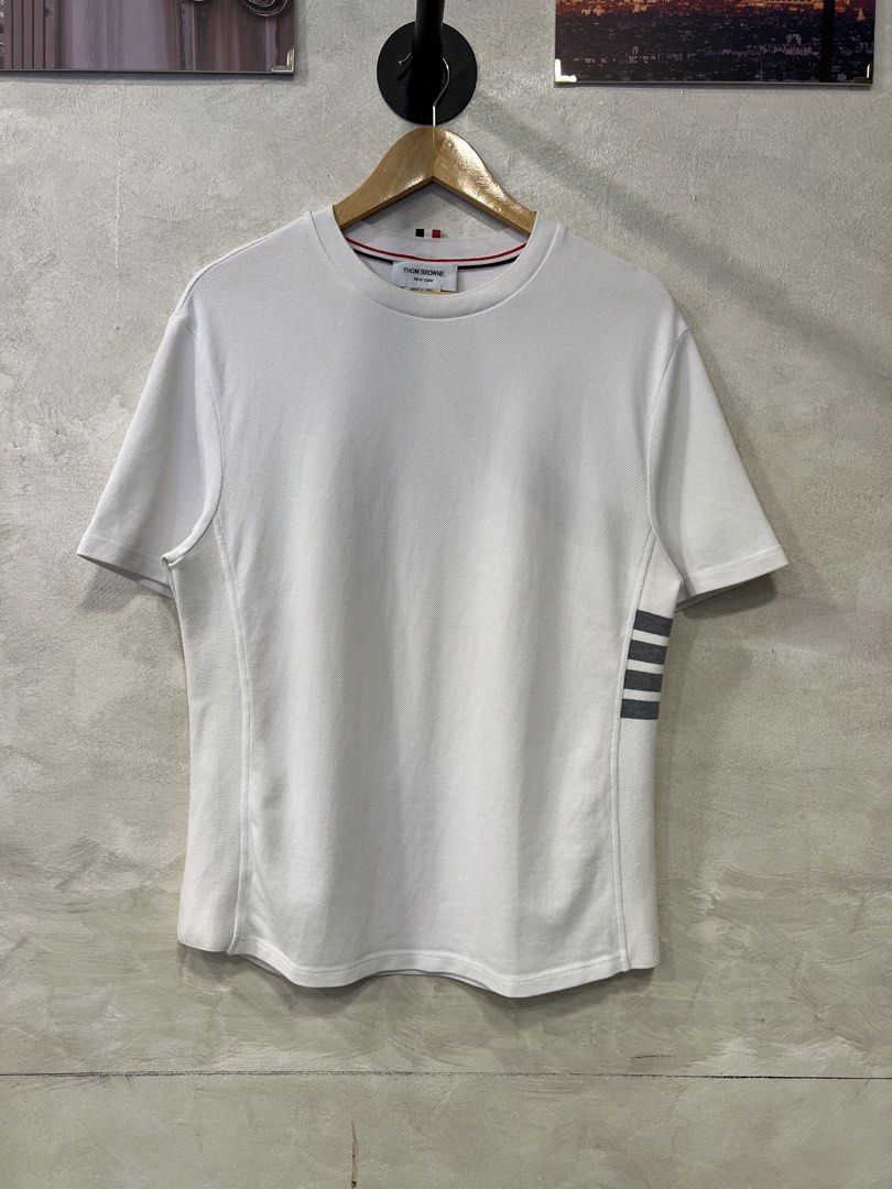 Thom Browne Classic Pique 4-Bar Tee (Category: Formal Shirts) located in Manila. Submitted by -handpick- (Listing ID 1466372640, Image 1). Description: Thom Browne Classic Pique 4-Bar Tee Features a crew neckline, signature grey 4-Bar stripes on the left side, and a signature tricolor grosgrain loop tab at the back neck. Size : 0 Dimensions : Length : 27 inches Width : 20 inches Shoulder : 18.5 inches Sleeve : 9.5 inches Sign of wear in good cond