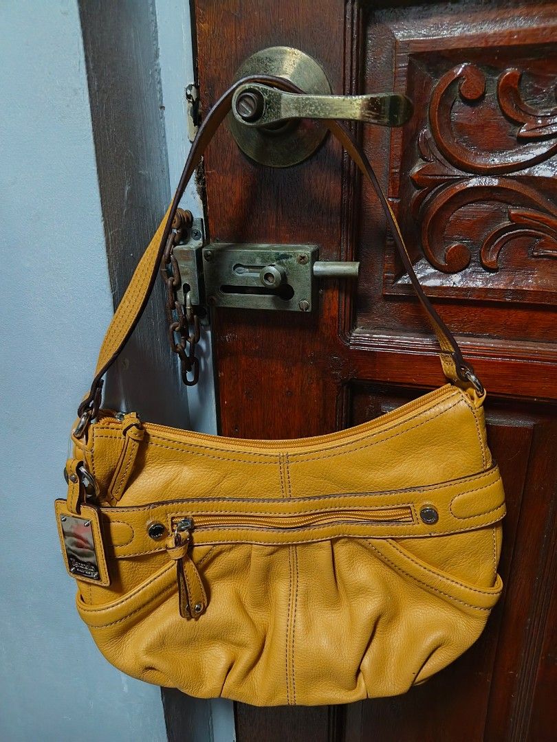 Tignanello Yellow Leather Shoulder Bag (Category: Shoulder Bags) located in Quezon City. Submitted by matcarla (Listing ID 1466517428, Image 1). Description: -Tignanello Bag From US - Color: Bright yellow - Material: Soft, high-quality leather - Exterior: Vertical front zip pocket, sturdy shoulder strap, metal logo plate - Interior: Patterned fabric lining with extra slip pockets for small items - Closure: Secure zip-top closure - Condition: Exce