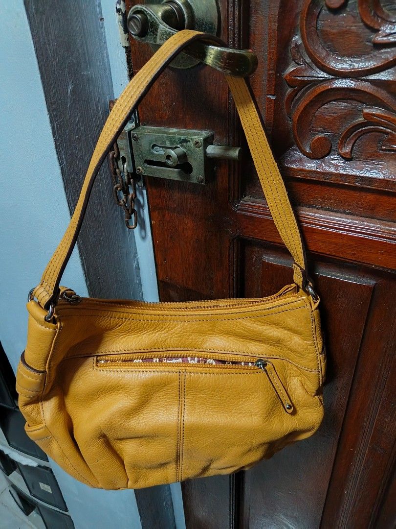 Tignanello Yellow Leather Shoulder Bag (Category: Shoulder Bags) located in Quezon City. Submitted by matcarla (Listing ID 1466517428, Image 3). Description: -Tignanello Bag From US - Color: Bright yellow - Material: Soft, high-quality leather - Exterior: Vertical front zip pocket, sturdy shoulder strap, metal logo plate - Interior: Patterned fabric lining with extra slip pockets for small items - Closure: Secure zip-top closure - Condition: Exce