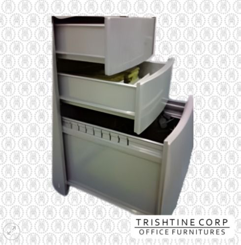 TMP-018 | Curved Handle Mobile Pedestal (Category: Office Furniture & Fixtures) located in Caloocan City. Submitted by jim.trishtineofficefurnitures (Listing ID 1466419844, Image 1). Description: - Brand: Trishtine Corp - Color: Sturdy grey finish - Storage: 3 pull-out drawers with varying depths - Top Drawers: Slide open easily for everyday supplies - Bottom Drawer: Equipped with hanging rails for important files - Condition: Great space-saving 