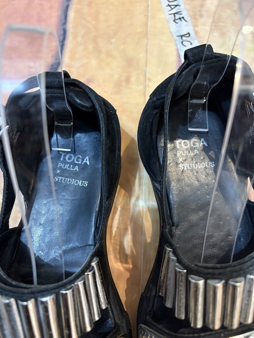 TOGA Pulla x Studious (Archive) (Category: Flats & Sandals) located in Echague. Submitted by jake_rc (Listing ID 1466427903, Image 2). Description: Toga Pulla x Studious Metal Sneaker Sandals, featuring distinctive engraved silver-tone metal hardware across the black leather straps. Size 37 on tag Total length 9.5 (best fit 9 inches) Signs of use Heel drags Price 980 plus SF.