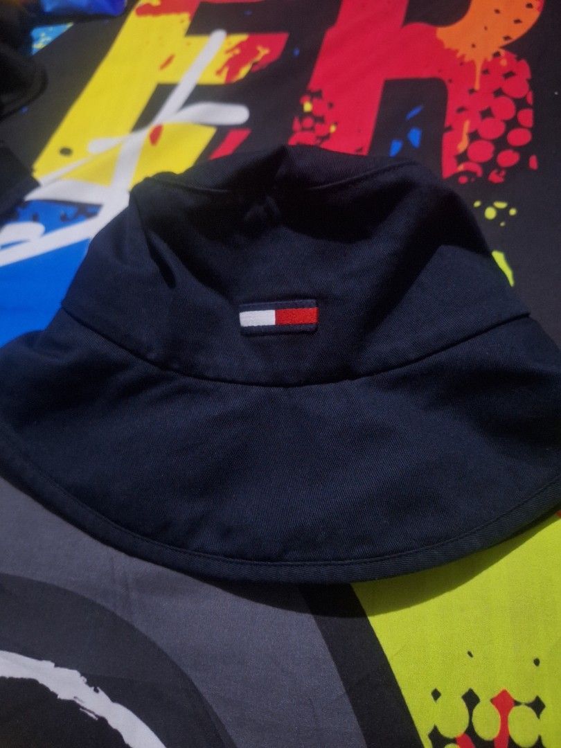 Tommy Jeans Navy Blue Bucket Hat OS (Category: Caps & Hats) located in Manila. Submitted by adolphreyes645 (Listing ID 1466539282, Image 1). Description: - Brand: Tommy Jeans - Color: Navy Blue - Size: OS (One Size) - Material: 100% Cotton - Design: Small embroidered flag logo on front, solid dark blue color - Features: Foldable and packable, classic streetwear style.