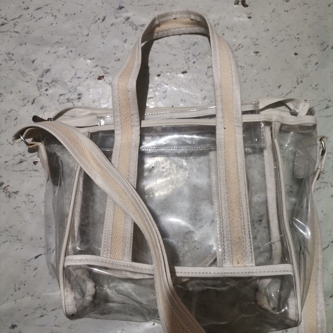Transparent Bag (Category: Cross-body Bags) located in Pasig City. Submitted by reyning (Listing ID 1466507194, Image 1). Description: 👜 transparent PVC tote features durable cream-colored canvas webbing handles and an adjustable shoulder strap 👜 Medium size.
