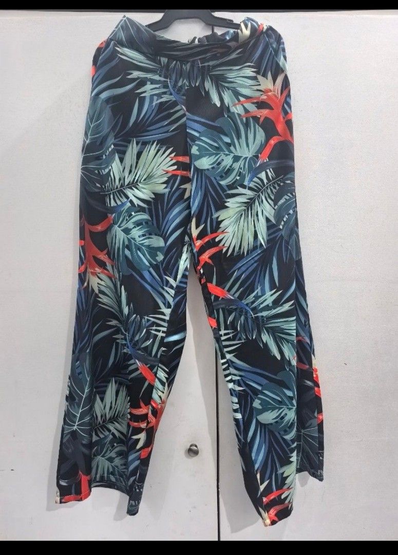 Tropical Leaf Print Wide Leg Pants (Category: Jeans) located in Calamba. Submitted by ouryardfindsog (Listing ID 1466393772, Image 3). Description: - Design: Tropical leaf print with dark blue base and green/red accents - with side pockets - Fit: Relaxed, flowy wide leg with a super stretchy elastic waistband - Comfort: Lightweight and comfortable for all-day wear - Styling: Easy to match with plain tank tops or tees - Occasion: Great for casual 