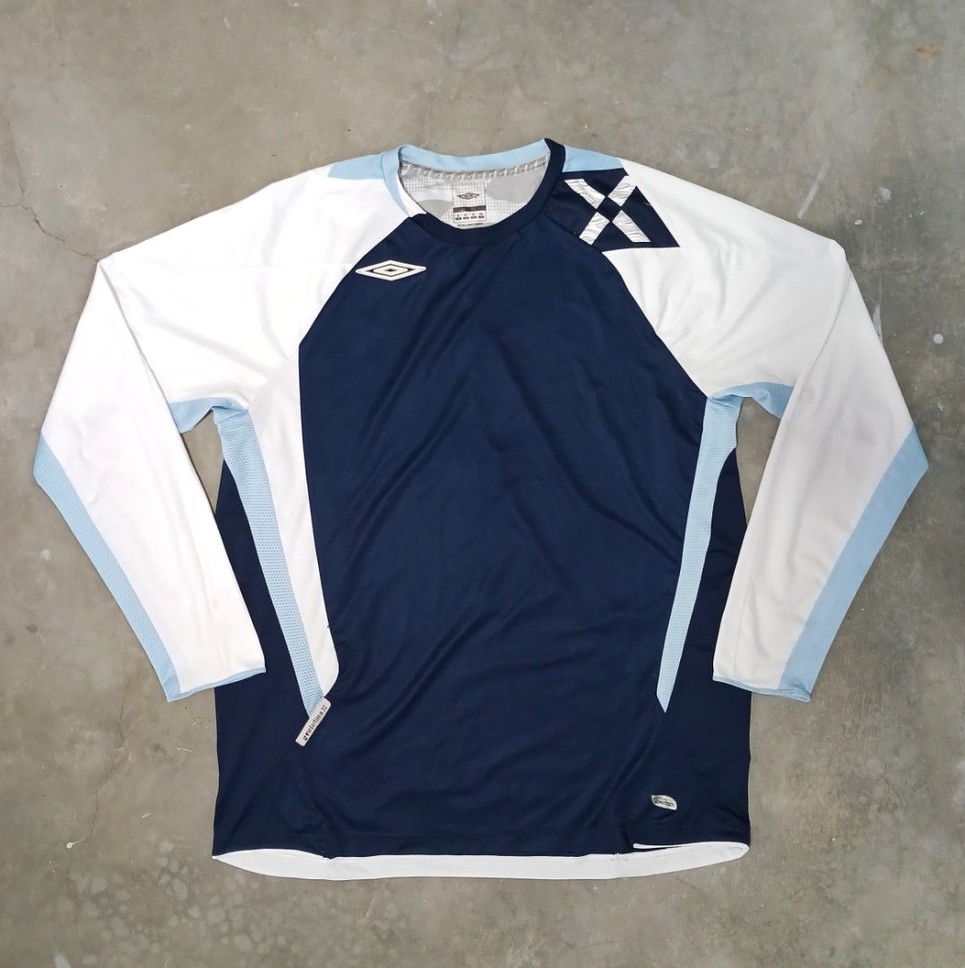Umbro Evolution X Long Sleeve Sports Shirt (Category: Activewear) located in Manila. Submitted by joefrey12 (Listing ID 1466544192, Image 1). Description: - Brand: Umbro (Evolution X Line) - Color: Navy blue body with white sleeves and light blue accent panels - Size: XL Dimes 23x29 - Material: Lightweight athletic fabric with breathable side mesh panels - Details: Classic Umbro diamond logo on chest, collar tag, and woven 'Evolution X' hem tab -