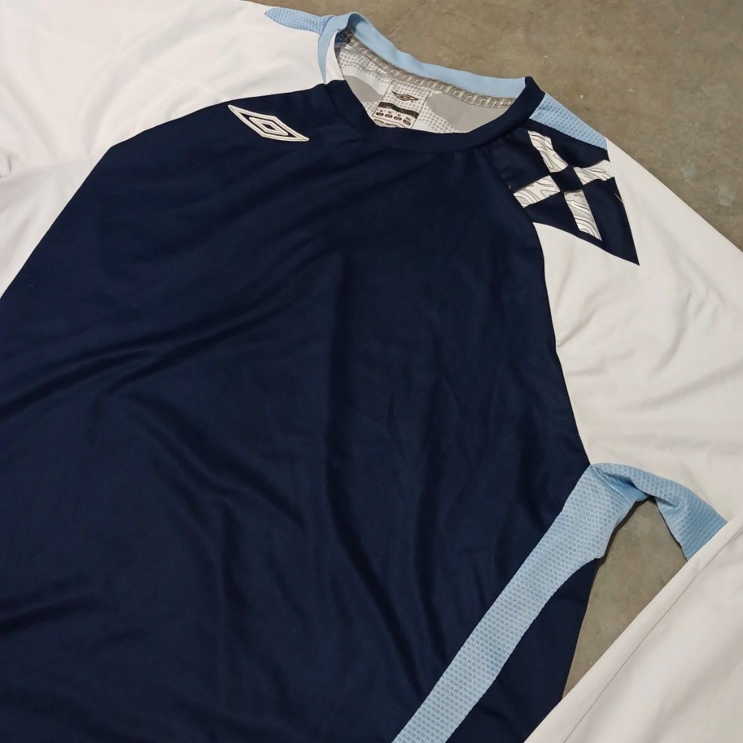 Umbro Evolution X Long Sleeve Sports Shirt (Category: Activewear) located in Manila. Submitted by joefrey12 (Listing ID 1466544192, Image 3). Description: - Brand: Umbro (Evolution X Line) - Color: Navy blue body with white sleeves and light blue accent panels - Size: XL Dimes 23x29 - Material: Lightweight athletic fabric with breathable side mesh panels - Details: Classic Umbro diamond logo on chest, collar tag, and woven 'Evolution X' hem tab -