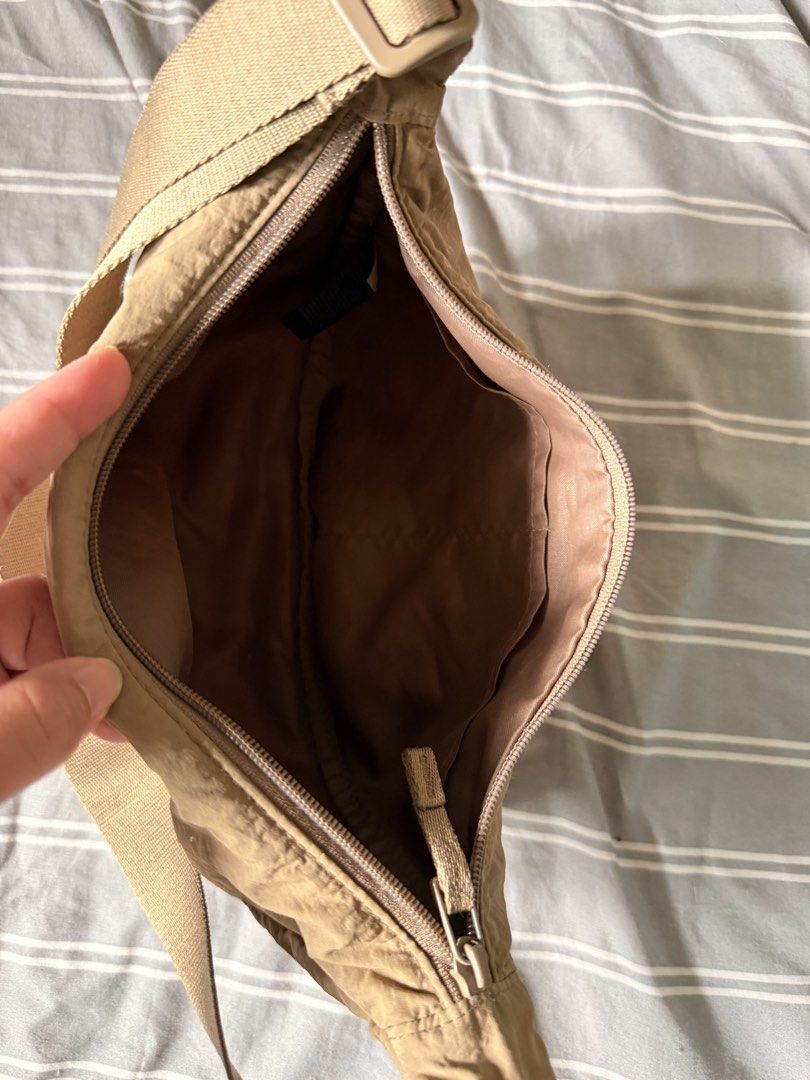 Uniqlo Round Mini Shoulder Bag Brown (Category: Cross-body Bags) located in Mandaluyong City. Submitted by ohayouclub (Listing ID 1466362174, Image 3). Description: - Brand: Uniqlo - Style: Round Mini Shoulder Bag (Crescent shape) - Color: Versatile beige brown - Material: Durable and lightweight nylon - Closure: Secure zipper with interior pockets for organization - Strap: Adjustable for a comfortable fit.