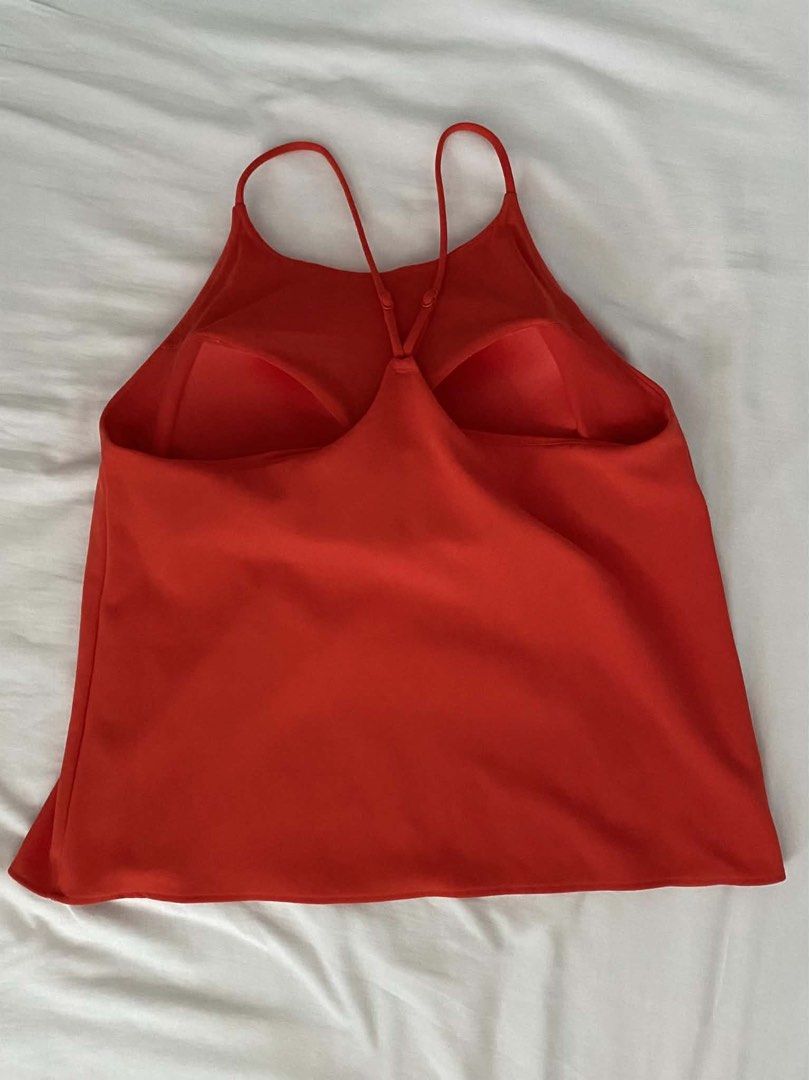 Uniqlo Spaghetti Blouse Size XL (Category: Sleeveless) located in Manila. Submitted by Mimi020623 (Listing ID 1466481625, Image 3). Description: - Brand: Uniqlo - Color: Bright red / solid orange-red - Size: XL (Fits bust 92-98cm) - Features: Built-in bra cups for hidden support - Straps: Adjustable thin straps with a criss-cross back design - Condition: excellent, super comfortable style.