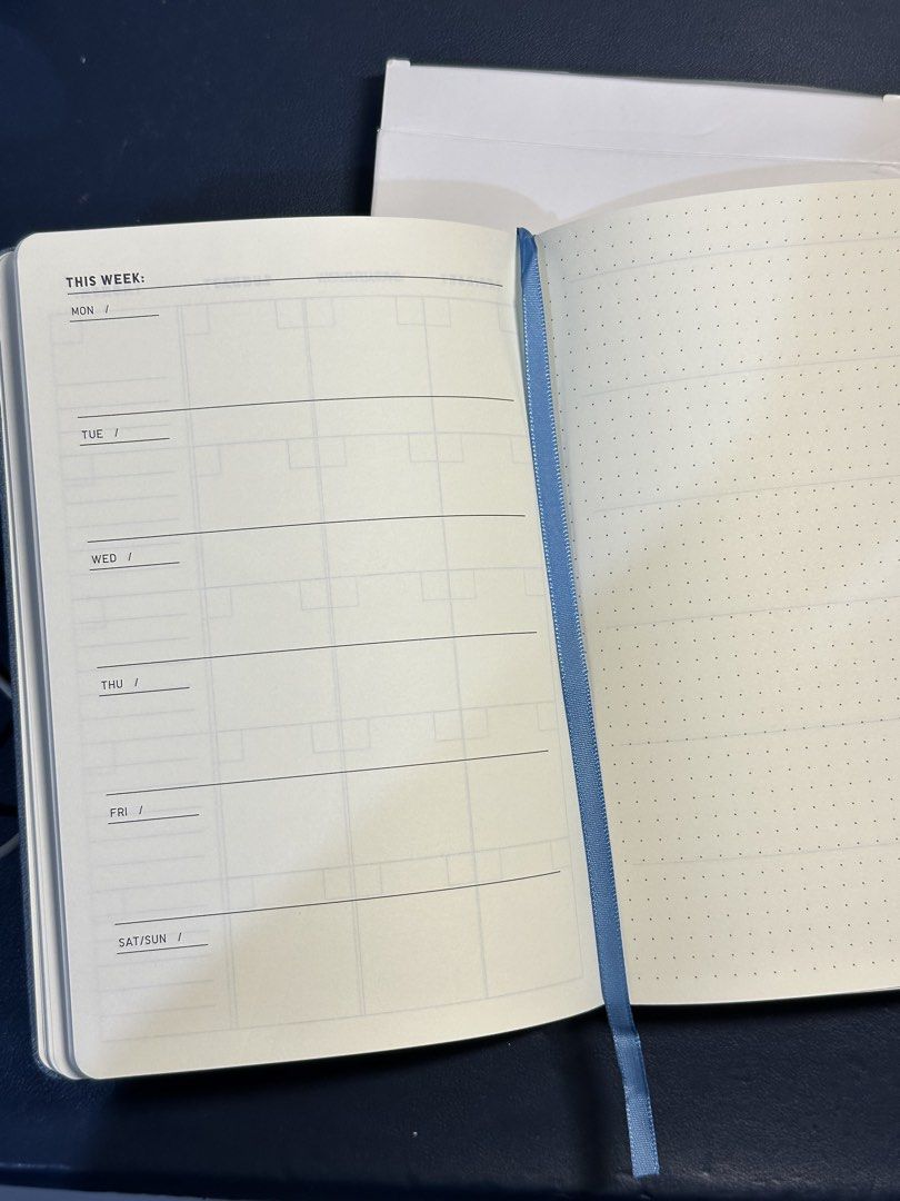 Uniqlo undated planner (Blue) (Category: Stationery & School Supplies) located in Manila. Submitted by elleflores (Listing ID 1466473217, Image 2). Description: - Brand: Uniqlo - Item: Hardcover Planner / Notebook - Color: Soft blue faux leather with debossed logo - Features: Elastic band closure and matching ribbon bookmark - Layout: Weekly layout on the left, dotted grid pages on the right.