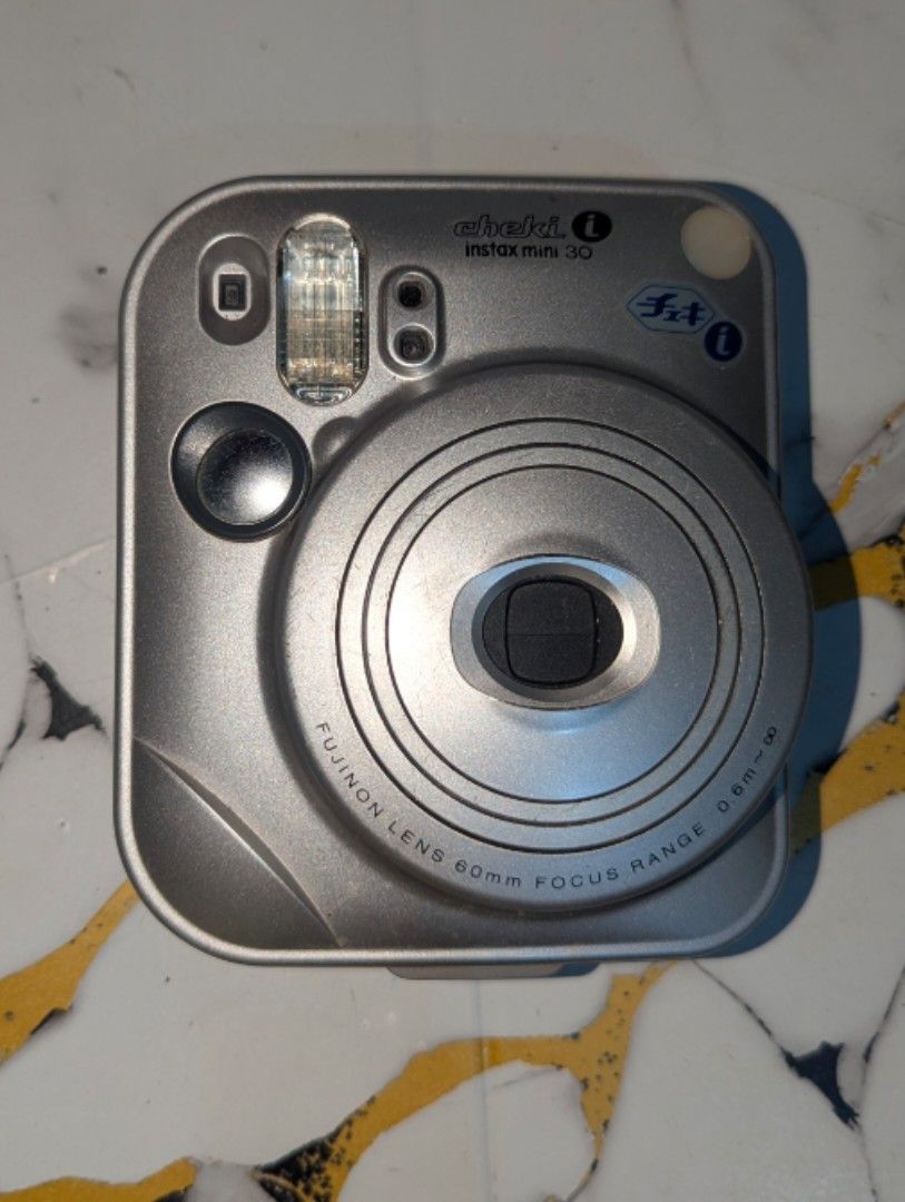 UNTESTED Fujifilm Instax Mini 30 Cheki Silver Instant Camera (Category: Cameras) located in Guiguinto. Submitted by matcha.designs (Listing ID 1466502721, Image 1). Description: - Model: Silver Fujifilm Instax Mini 30 instant film camera - Features: Compact square body, built-in flash, optical viewfinder - Film & Power: Uses Instax Mini instant film and standard CR2 batteries - Focus: Lens focal range from 0.6m to infinity - Condition: Tested, me