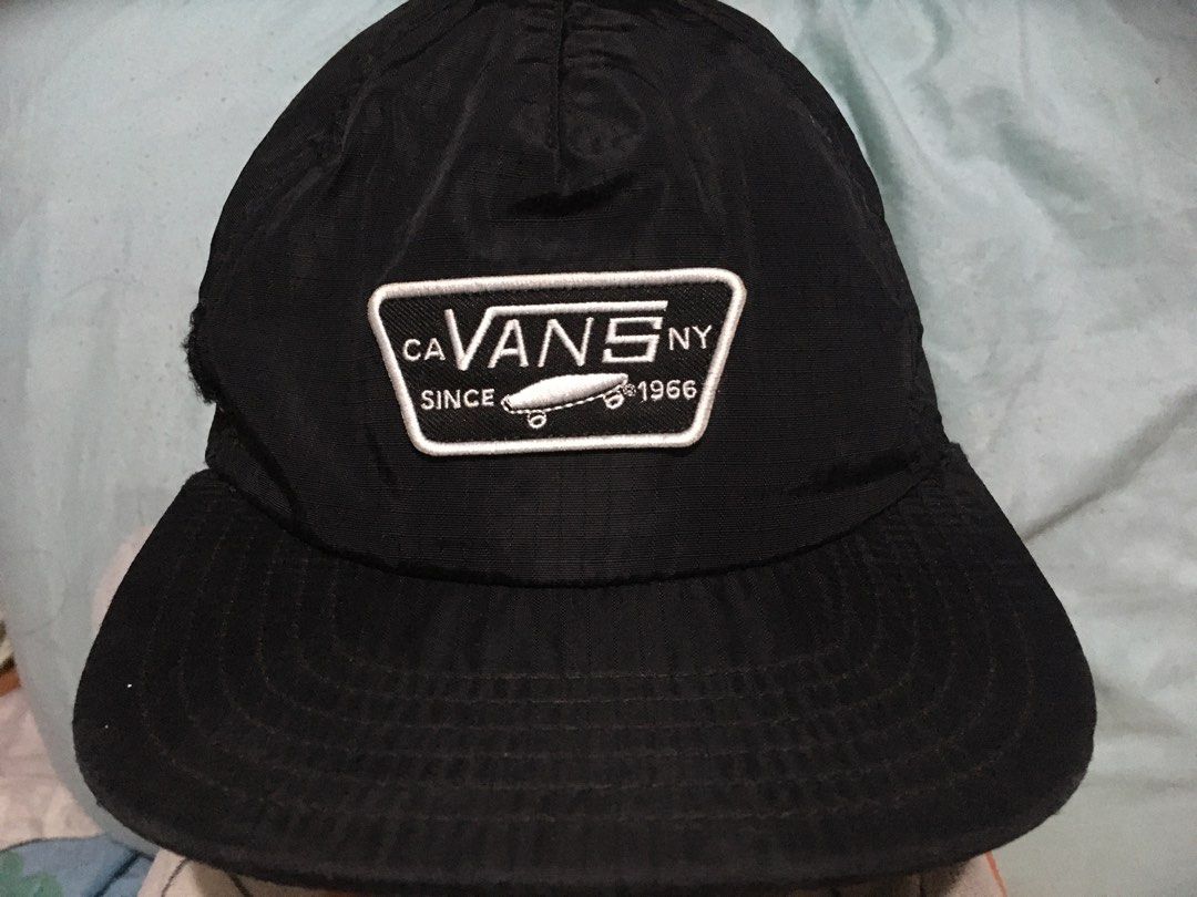 Vans CA NY Since 1966 Black Hat Cap (Category: Caps & Hats) located in Bacoor. Submitted by qualityucantrust (Listing ID 1466387604, Image 1). Description: - Brand: Vans - Color: Classic black - Design: Front patch with skateboard graphic and lettering, plus a small Vans tag on the back FREE:STICKERS - Material: Lightweight nylon/synthetic fabric - Fit: Adjustable strap closure at the back - Condition: Clean outer structure, but please note there