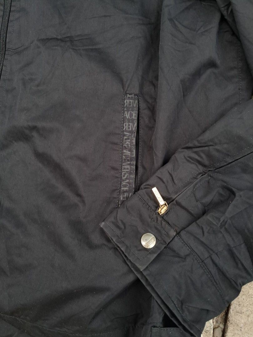 Versace Classic Black Zip-Up Jacket (Category: Coats, Jackets and Outerwear) located in Cebu City. Submitted by chill_zy (Listing ID 1466366610, Image 3). Description: - Brand: Versace Classic - Color: Black with white logo-print inner lining - Closure: Full front zipper with branded hardware - Details: Versace lettering on pocket trim and branded metal snaps - Cuffs: Adjustable button cuffs with classic collar style - Material: Lightweight, dura