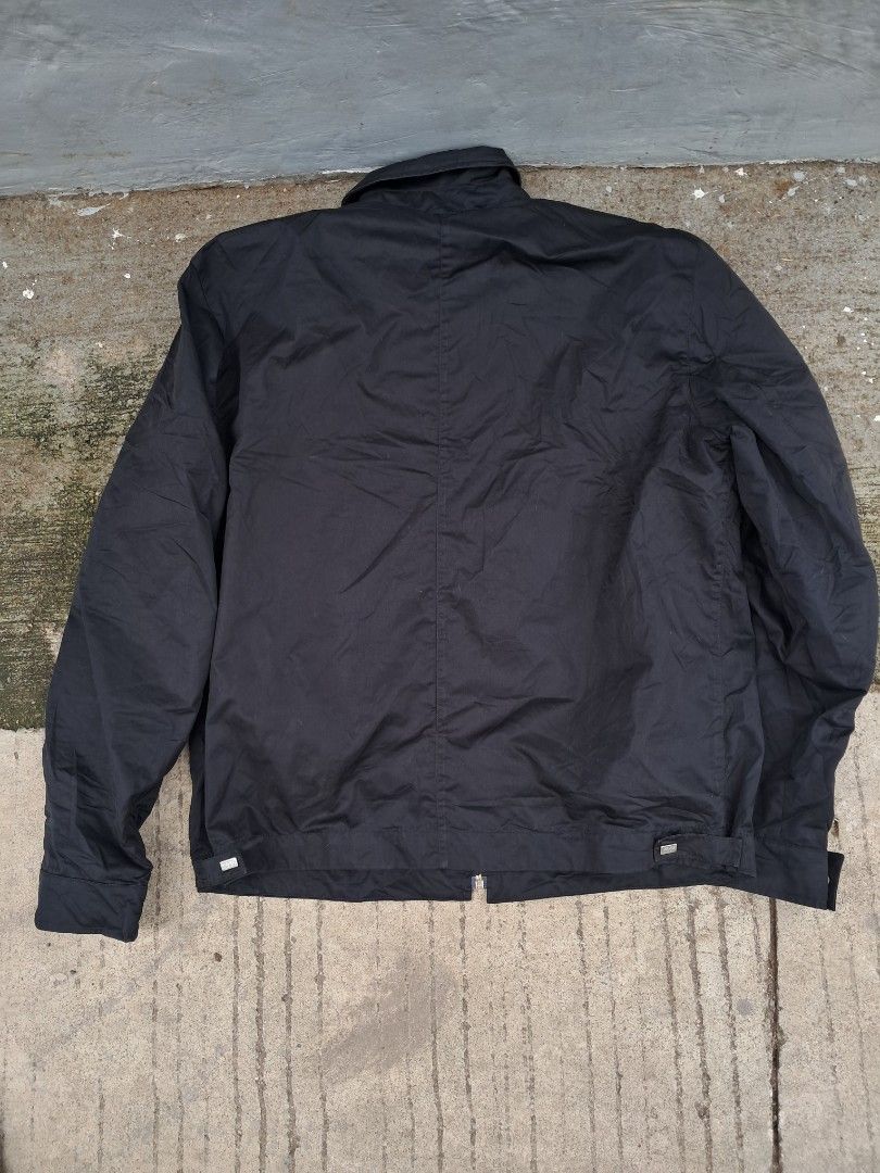 Versace Classic Black Zip-Up Jacket (Category: Coats, Jackets and Outerwear) located in Cebu City. Submitted by chill_zy (Listing ID 1466366610, Image 2). Description: - Brand: Versace Classic - Color: Black with white logo-print inner lining - Closure: Full front zipper with branded hardware - Details: Versace lettering on pocket trim and branded metal snaps - Cuffs: Adjustable button cuffs with classic collar style - Material: Lightweight, dura