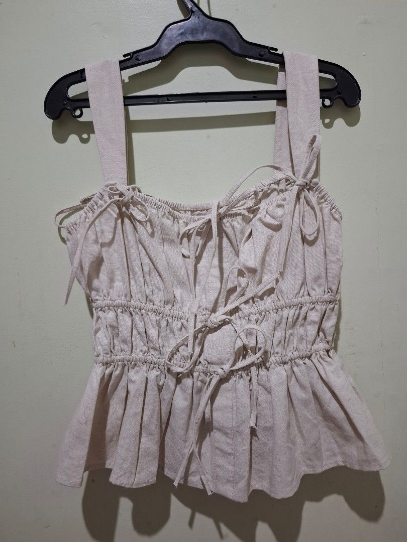 Vibes Beige Ruched Peplum Top with Bow Ties (Category: Sleeveless) located in Tuguegarao City. Submitted by potaetonim (Listing ID 1466476856, Image 1). Description: - Brand: Vibes - Color: Beige - Details: Heavy front and back ruching, tie-up shoulder straps, decorative center bows - Design: Flared peplum hem with textured vertical stitching - Condition: Excellent, clean inner label - Style: Coquette, feminine, trendy.