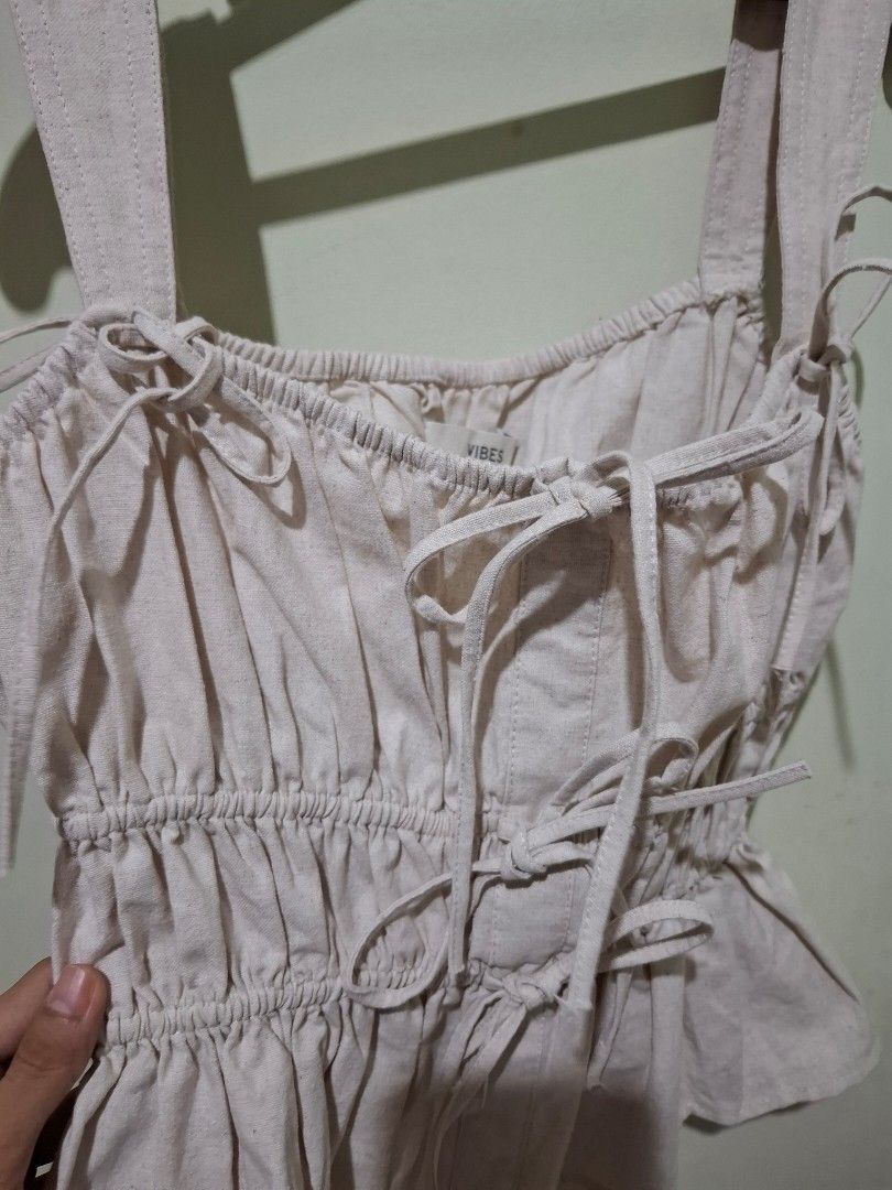 Vibes Beige Ruched Peplum Top with Bow Ties (Category: Sleeveless) located in Tuguegarao City. Submitted by potaetonim (Listing ID 1466476856, Image 3). Description: - Brand: Vibes - Color: Beige - Details: Heavy front and back ruching, tie-up shoulder straps, decorative center bows - Design: Flared peplum hem with textured vertical stitching - Condition: Excellent, clean inner label - Style: Coquette, feminine, trendy.