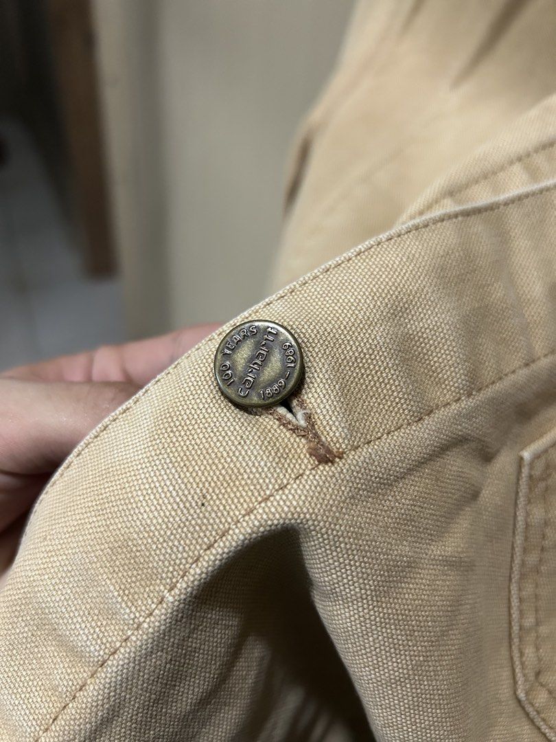 Vintage Carhartt 1989 Chore Jacket (Category: Coats, Jackets and Outerwear) located in Los Banos. Submitted by remynextdoor (Listing ID 1466392216, Image 2). Description: - Brand: Carhartt - 23.5x26 - Style: Vintage 100 Years (1889-1989) Canvas Chore Jacket - Color: Tan with contrast brown corduroy collar, pocket flaps, and cuffs - Details: Special commemorative stamped metal buttons and multiple front utility pockets - Sizing: Flat lay width mea
