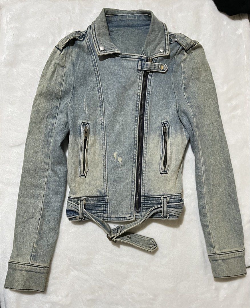Vintage Light Wash Denim Biker Jacket (Category: Coats, Jackets and Outerwear) located in Cagayan de Oro. Submitted by prelovedbynmei (Listing ID 1466563314, Image 2). Description: - Style: Moto biker denim jacket - Wash: Light wash blue with distressed details - Closure: Asymmetrical front zipper - Collar: Lapel collar with snap buttons - Pockets: Functional zippered front pockets - Details: Integrated belt with buckle at the hem and shoulder ep