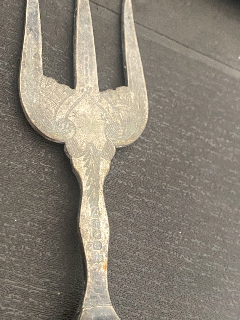 Vintage Three Tine Fork With Bone Handle (Category: Vintage Collectibles) located in General Trias. Submitted by mangu_ukay (Listing ID 1466358445, Image 2). Description: - Vintage three-tine serving fork with elegant appeal - Ornate floral engraving located right above the neck - Smooth cream-coloured handle fitted with a decorative metal collar - Stamped with small hallmarks on the metal - Condition: Shows vintage patina, tarnishing on the silv