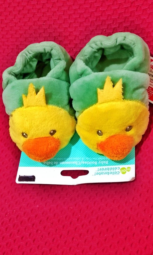 Duck Plush Infant Baby Booties (Category: Babies & Kids Fashion) located in Cabanatuan. Submitted by miss.maia (Listing ID 1466544728, Image 3). Description: These are the Way To Celebrate! Duck Plush Infant Baby Booties, designed as soft, slip-on seasonal footwear for infants. They feature plush green fabric ankle cuffs paired with a bright yellow duck face, a soft orange beak, and a crown-like yellow tuft on top..