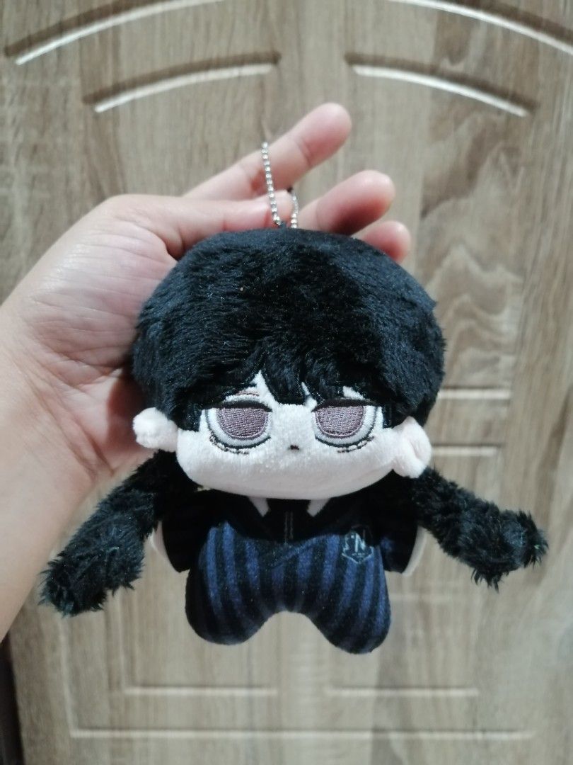 Wednesday Addams Plush Keychain (Category: Plushies & Soft Toys) located in Angono. Submitted by rlinee_93 (Listing ID 1466464773, Image 2). Description: - Character: Wednesday Adddams hair Twisted - Outfit: Night Raven College uniform with blue and black stripes - Features: Soft black hair, sleepy expression, and embroidered face details - Attachment: Silver ball chain for easy hanging on bags or keys - Condition: Clean, and well-maintained.
