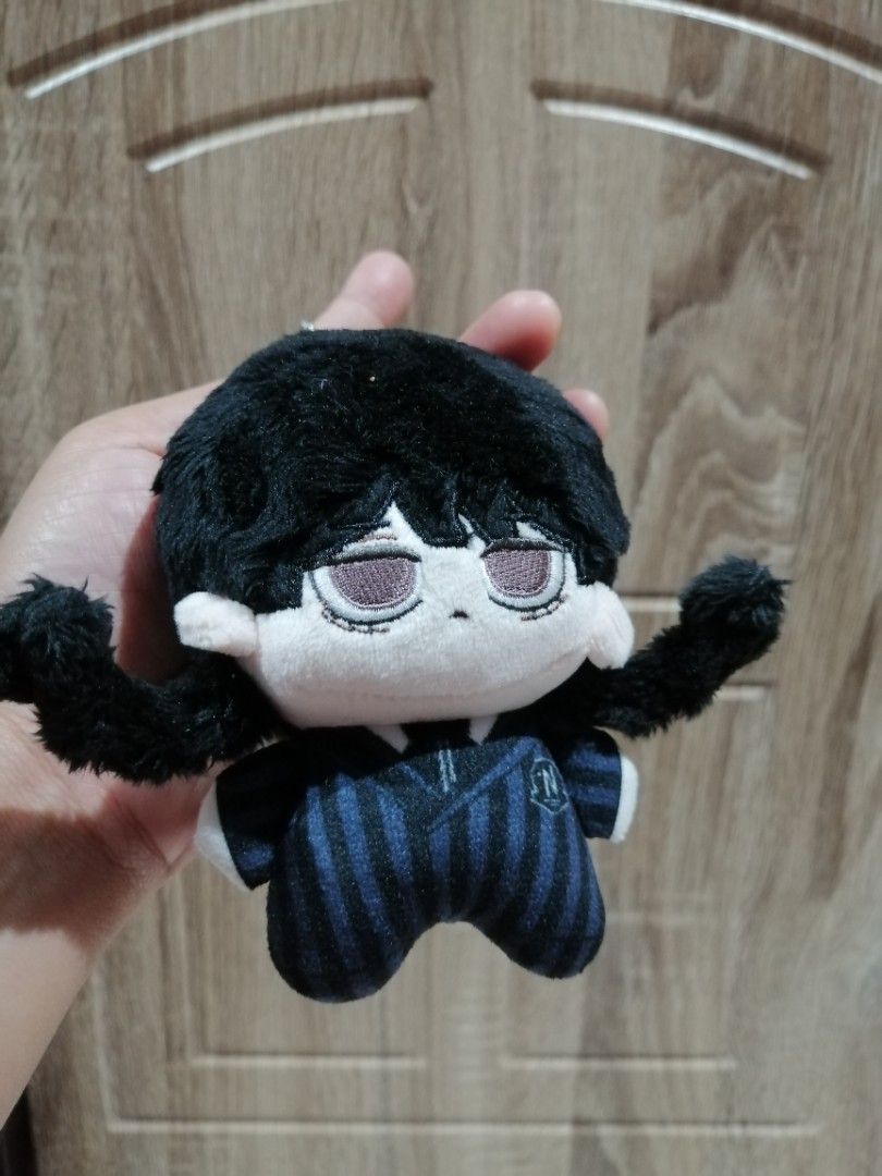 Wednesday Addams Plush Keychain (Category: Plushies & Soft Toys) located in Angono. Submitted by rlinee_93 (Listing ID 1466464773, Image 1). Description: - Character: Wednesday Adddams hair Twisted - Outfit: Night Raven College uniform with blue and black stripes - Features: Soft black hair, sleepy expression, and embroidered face details - Attachment: Silver ball chain for easy hanging on bags or keys - Condition: Clean, and well-maintained.