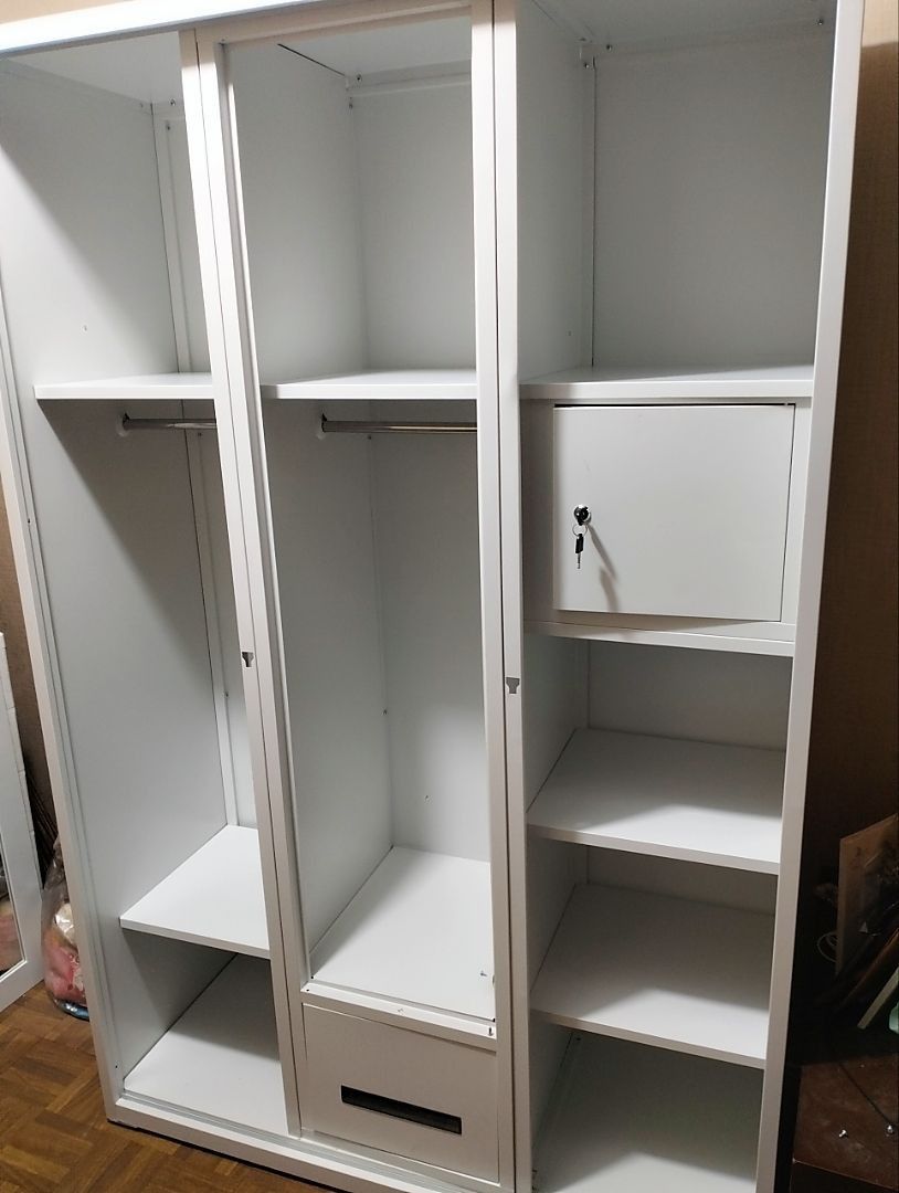 White 3-Section Wardrobe with Hanging Rods and Lockable Compartment (Category: Shelves, Cabinets & Racks) located in Caloocan City. Submitted by swiftdolphin.2aa81b (Listing ID 1466356047, Image 1). Description: White metal or wooden wardrobe setup. Two sections include clothes hanging rails with top and bottom shelves. Middle section has a bottom drawer. Right section features multiple open shelves plus a small lockable compartment with keys. Cl