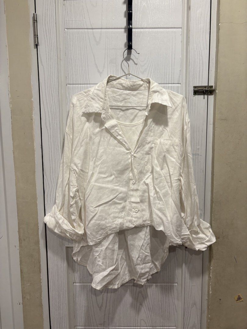 White Button-Up Shirt with Attached Inner Tank Top (Category: Shirts) located in Mandaluyong City. Submitted by shopwithjuu (Listing ID 1466421911, Image 1). Description: White oversized button-up shirt with a built-in inner tank top layer. Features a relaxed fit, classic collar, chest pocket, and high-low hem. Lightweight and perfect for casual everyday layering..