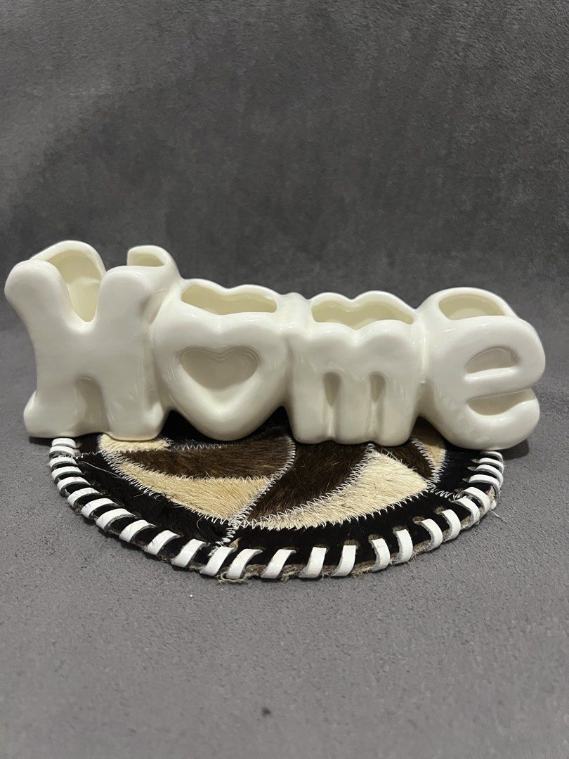 White Ceramic HOME Letter Vase Holder (Category: Vases & Decorative Bowls) located in Las Pinas. Submitted by maple0305 (Listing ID 1466413403, Image 2). Description: - Material: White ceramic with a glossy finish - Design: Home lettering with 4 distinct compartments - Condition: Smooth surface, no chips or cracks, sits flat on any tabletop - Perfect for: Small flowers or plant propagations - Aesthetic: Neutral color that complements most room de