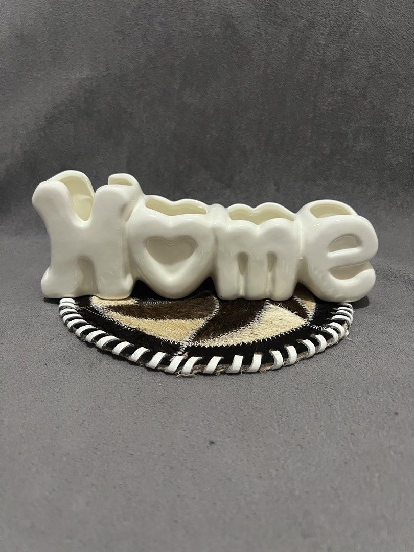 White Ceramic HOME Letter Vase Holder (Category: Vases & Decorative Bowls) located in Las Pinas. Submitted by maple0305 (Listing ID 1466413403, Image 1). Description: - Material: White ceramic with a glossy finish - Design: Home lettering with 4 distinct compartments - Condition: Smooth surface, no chips or cracks, sits flat on any tabletop - Perfect for: Small flowers or plant propagations - Aesthetic: Neutral color that complements most room de