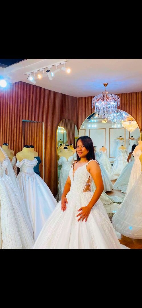 White lace wedding gown with long train (Category: Evening dresses & gowns) located in Caloocan City. Submitted by rhianskie (Listing ID 1466374918, Image 2). Description: - Condition: Worn only during my wedding - Style: sleeveless bodice with intricate lace detailing - Skirt: Full, voluminous ballgown skirt layered in tulle - Back Design: Deep V-back with a delicate row of buttons - Train: Dramatic floor-sweeping train with a sheer outer tulle 