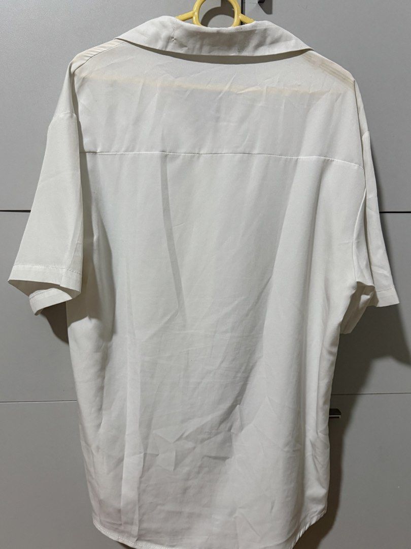 White Short Sleeve Button Up Shirt XL (Category: Shirts) located in Manila. Submitted by mpt99876 (Listing ID 1466523053, Image 3). Description: - Color: White - Size: XL - Style: Classic camp collar, button-up with curved hem - Fit: Relaxed - Material: Lightweight fabric - Ideal for: Warm weather and casual wear.