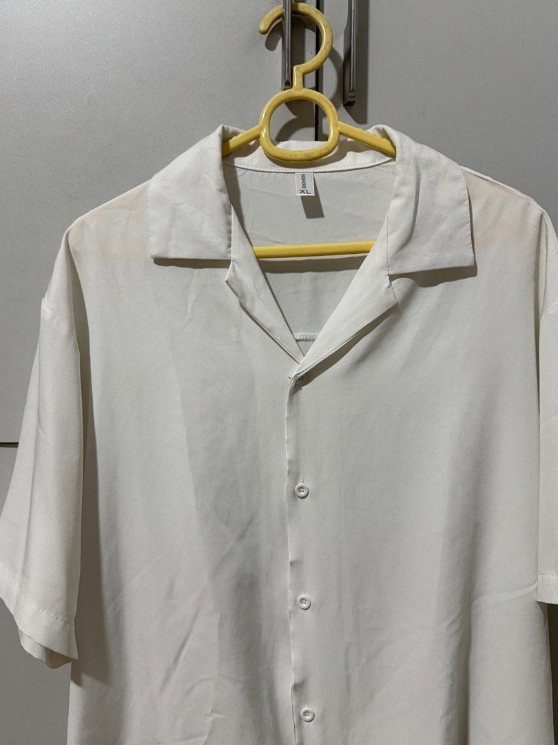 White Short Sleeve Button Up Shirt XL (Category: Shirts) located in Manila. Submitted by mpt99876 (Listing ID 1466523053, Image 2). Description: - Color: White - Size: XL - Style: Classic camp collar, button-up with curved hem - Fit: Relaxed - Material: Lightweight fabric - Ideal for: Warm weather and casual wear.
