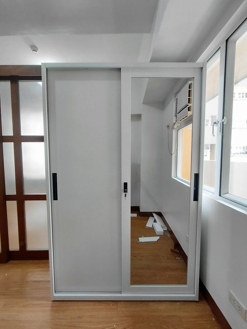 White Sliding Door Wardrobe with Mirror (Category: Shelves, Cabinets & Racks) located in Caloocan City. Submitted by swiftdolphin.2aa81b (Listing ID 1466354505, Image 1). Description: - Type: Two-door sliding wardrobe - Color: Clean modern white - Features: One solid white panel and one full-length mirror - Hardware: Sleek black vertical handles - Security: Key lock included on the mirrored door.