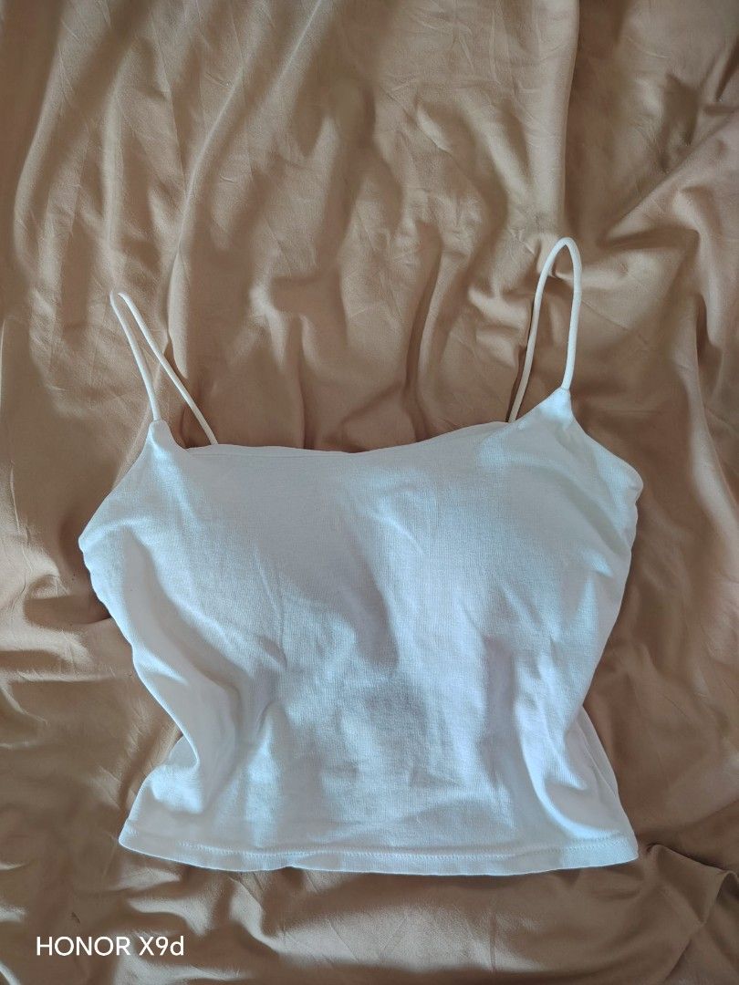 White Spaghetti Strap Crop Top Open Back Camisole (Category: Sleeveless) located in Mabalacat. Submitted by Jackikay.PreLoved (Listing ID 1466441752, Image 1). Description: - Size: Small-Medium - Color: White - Fabric: Super lightweight, soft stretch cotton, perfect for hot weather - Design: Thin double straps, square neckline, and unique low back cut - Features: Built-in padded bra section (no need for innerwear).