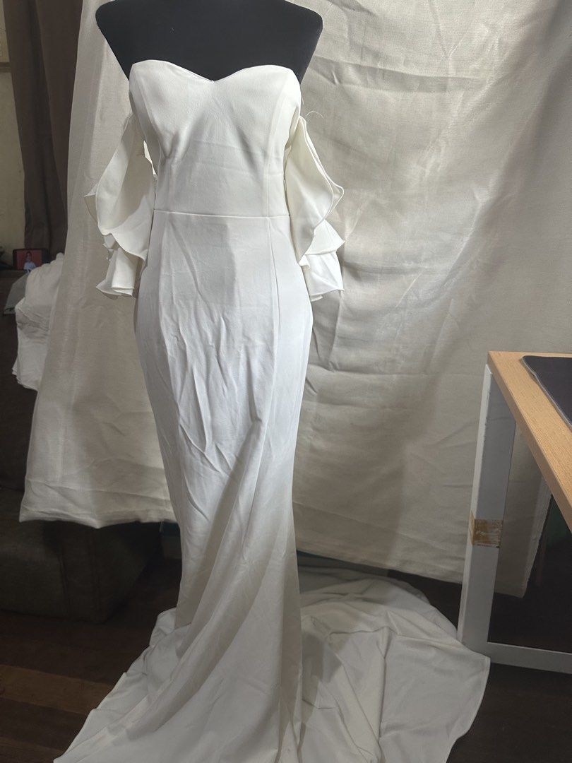 White Wedding Dress Large (Category: Evening dresses & gowns) located in Pasay City. Submitted by kimverlygo50697 (Listing ID 1466399101, Image 3). Description: - Color: White - Size: Large - Neckline: Sweetheart - Sleeves: Ruffled cold-shoulder - Silhouette: Fitted with a long floor-sweeping train - Style: Simple and clean design.