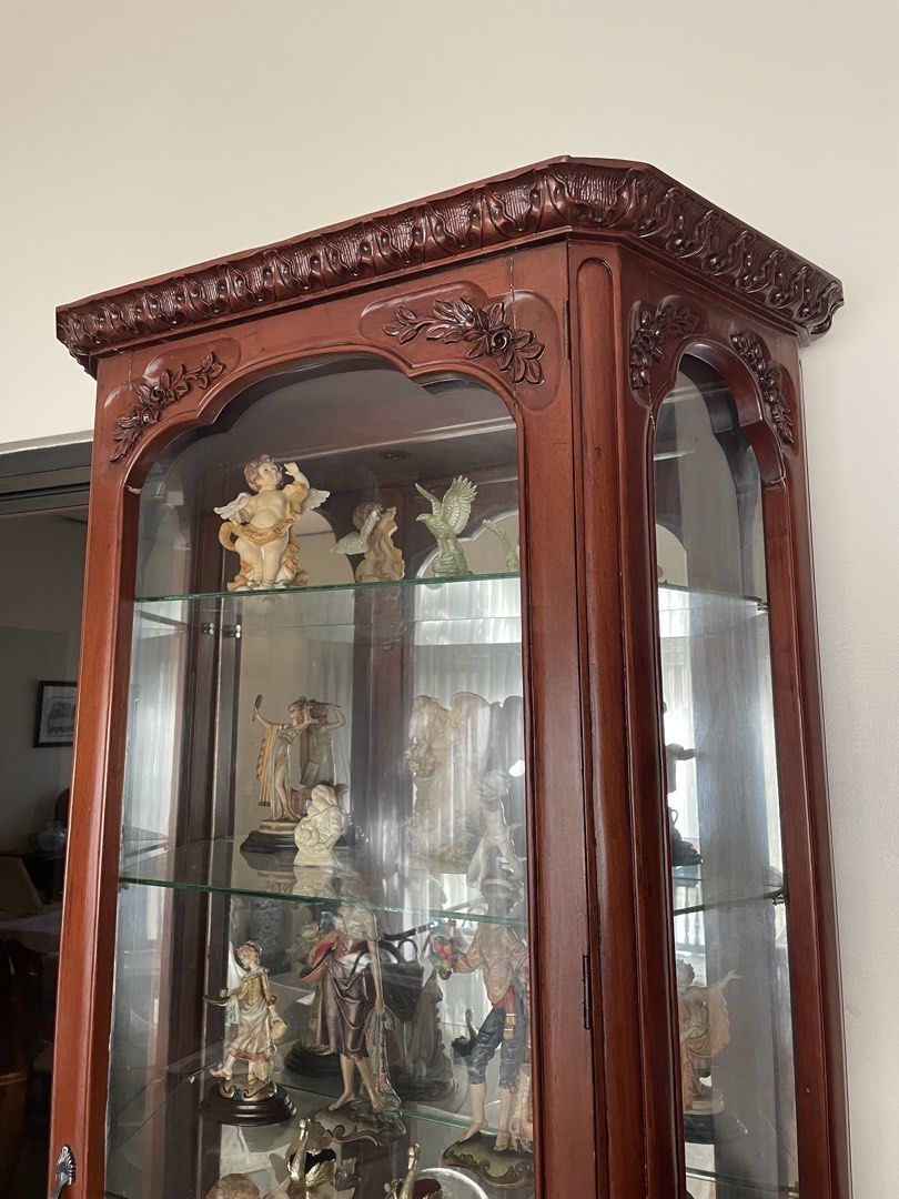Wooden Glass Display Cabinet (Category: Shelves, Cabinets & Racks) located in Quezon City. Submitted by belirankrstn (Listing ID 1466408568, Image 3). Description: Elegant wooden display cabinet with intricate carved details, glass panels, and multiple glass shelves. Perfect for displaying figurines, porcelain, collectibles, and decor. Good condition and well-maintained..
