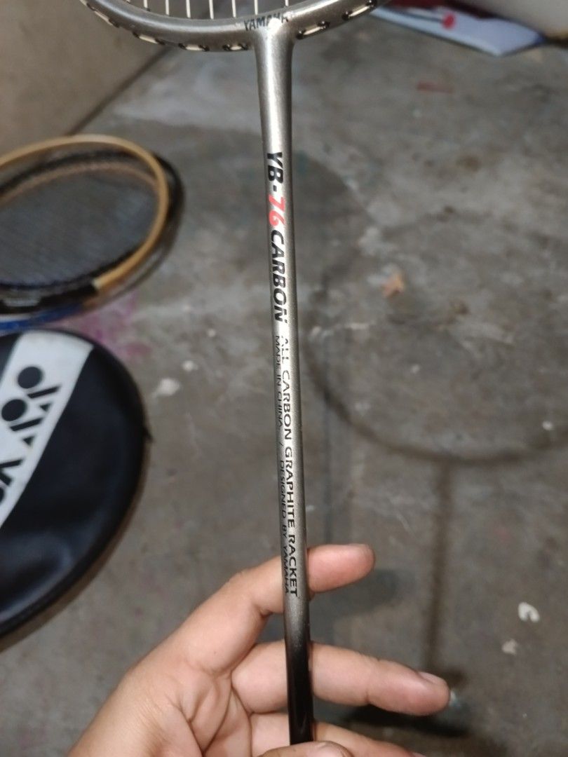 Yamaha YB-76 Badminton Racket (Category: Racket and Ball Sports) located in Valenzuela. Submitted by relchris22 (Listing ID 1466352470, Image 3). Description: - Model: Yamaha YB-76 Carbon - Design: All-carbon graphite racket designed by Yamaha, made in China - Strings: Standard string pattern installed - Grip: Wrapped with a purple overgrip - Condition: Shows minor signs of wear and tear on the frame and grip from regular play.