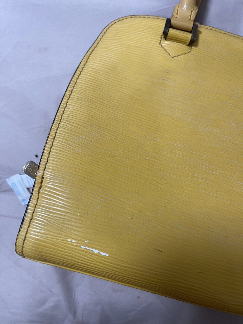 Yellow Leather Handbag (Category: Luxury Bags & Wallets) located in Taguig. Submitted by 1307maloc (Listing ID 1466397515, Image 2). Description: - Brand: Louis Vuitton - Model: Epi Leather Handbag - Color: Bright Yellow with purple interior lining - Material: Textured Epi leather - Features: Double top handles, secure zippered main compartment, gold-tone hardware, structured design Take note of the minor leather damages. Needs cleaning.