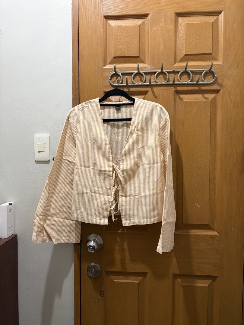 Yellow striped long sleeve tie-front blouse (Category: Blouses) located in Manila. Submitted by sooprmav (Listing ID 1466547847, Image 1). Description: - Yellow and white striped top - Long bell sleeves with cuffs - Tie-front closure at the center - Lightweight fabric with a flattering V-neckline - Easy to pair with jeans or skirts for a clean, comfortable look.