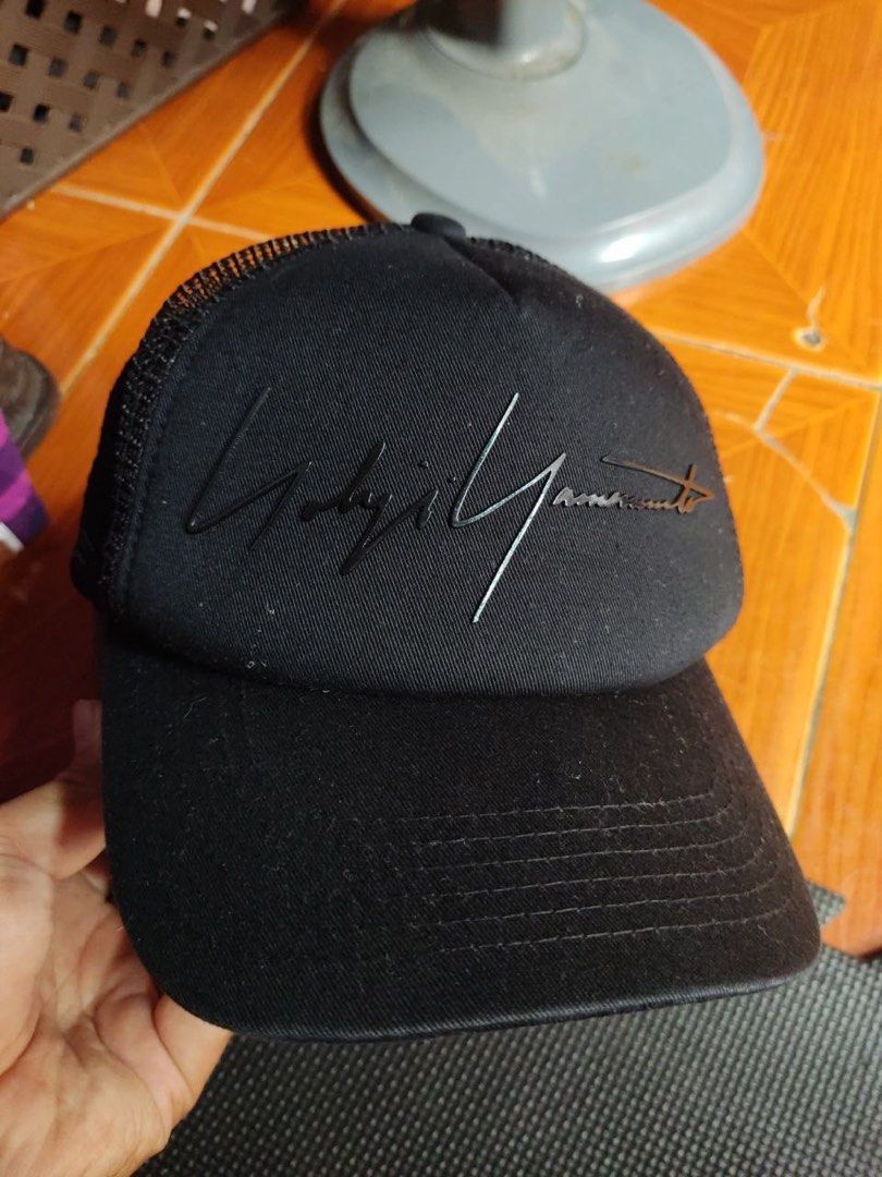Yohji Yamamoto Black Trucker Cap (Category: Caps & Hats) located in Caloocan City. Submitted by neweagle-424b (Listing ID 1466390738, Image 1). Description: - Brand: Yohji Yamamoto (Coverbrain tag) - Color: Classic all-black - Design: Embroidered Yohji signature on structured front crown, curved brim - Material: 60% cotton, 40% polyester - Back: Breathable mesh panels with adjustable matching black snapback closure - Fit: Standard adult sizing.