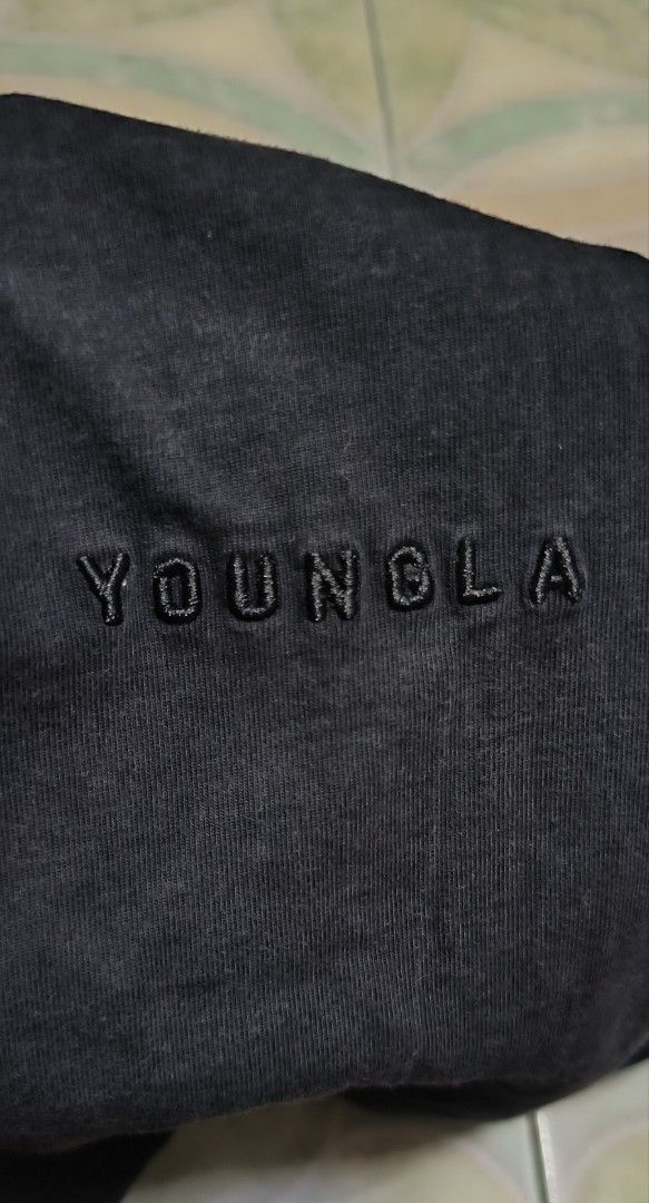 YoungLA Black T-Shirt (Category: Tshirts & Polo Shirts ) located in Manila. Submitted by itsmelawrence (Listing ID 1466359046, Image 3). Description: - Brand: YoungLA - Color: Black 9.2/10 - Size: Small (S) 21x28 - Design: Tonal embroidered YoungLA logo on chest with small YLA hem tag - Details: Interior printed neck label with Los Angeles branding and website - Versatile: Perfect for workouts or everyday casual wear - Condition: Brand new / Exce