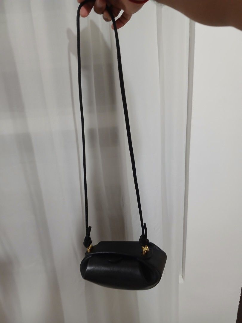 Yuzefi Black Leather Shoulder Bag (Category: Shoulder Bags) located in Quezon City. Submitted by mcenon35 (Listing ID 1466480023, Image 2). Description: - Brand: Yuzefi - Material: Premium black leather with gold-tone hardware - Design: Structured compact bag with gold logo stamped on the front flap - Strap: Thin black strap featuring stylish knot details on the sides - Condition: Clean, well-maintained overall - Capacity: Ideal size for your dai