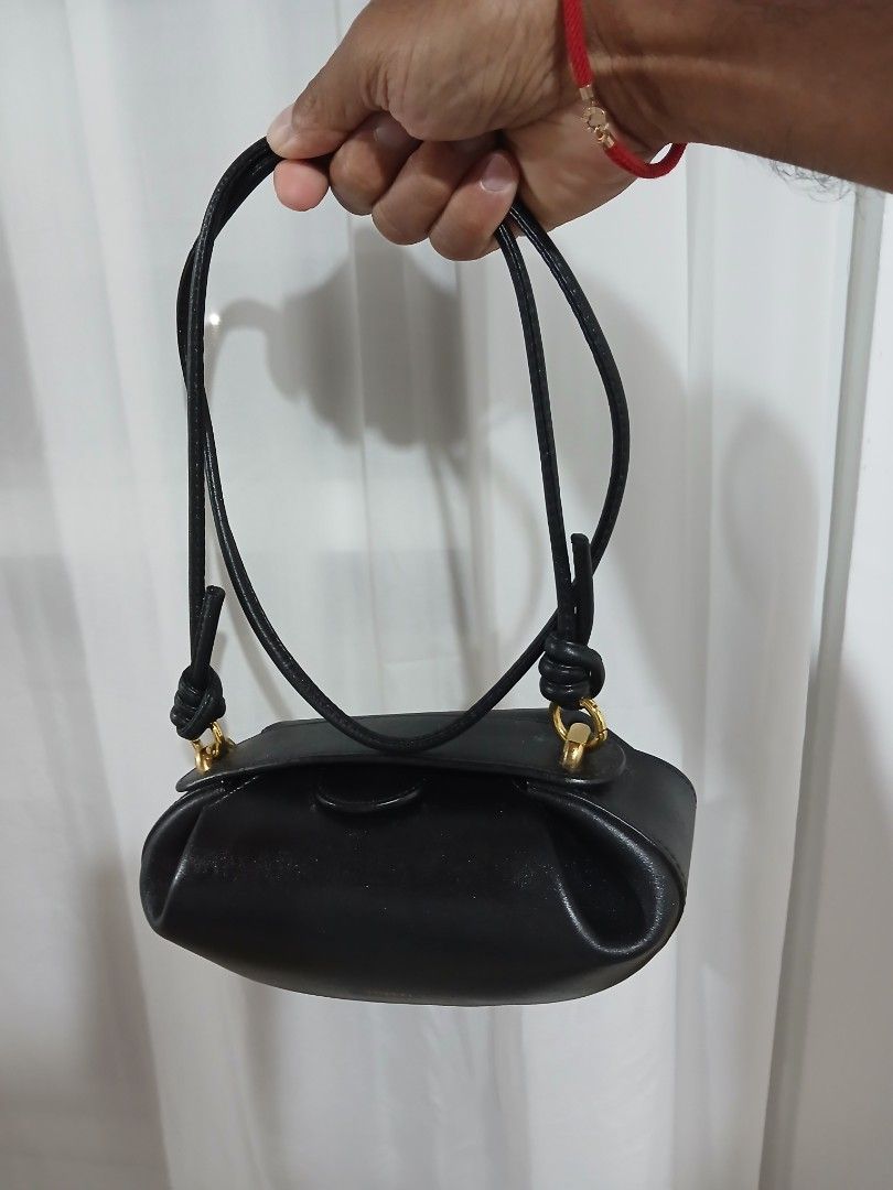 Yuzefi Black Leather Shoulder Bag (Category: Shoulder Bags) located in Quezon City. Submitted by mcenon35 (Listing ID 1466480023, Image 1). Description: - Brand: Yuzefi - Material: Premium black leather with gold-tone hardware - Design: Structured compact bag with gold logo stamped on the front flap - Strap: Thin black strap featuring stylish knot details on the sides - Condition: Clean, well-maintained overall - Capacity: Ideal size for your dai