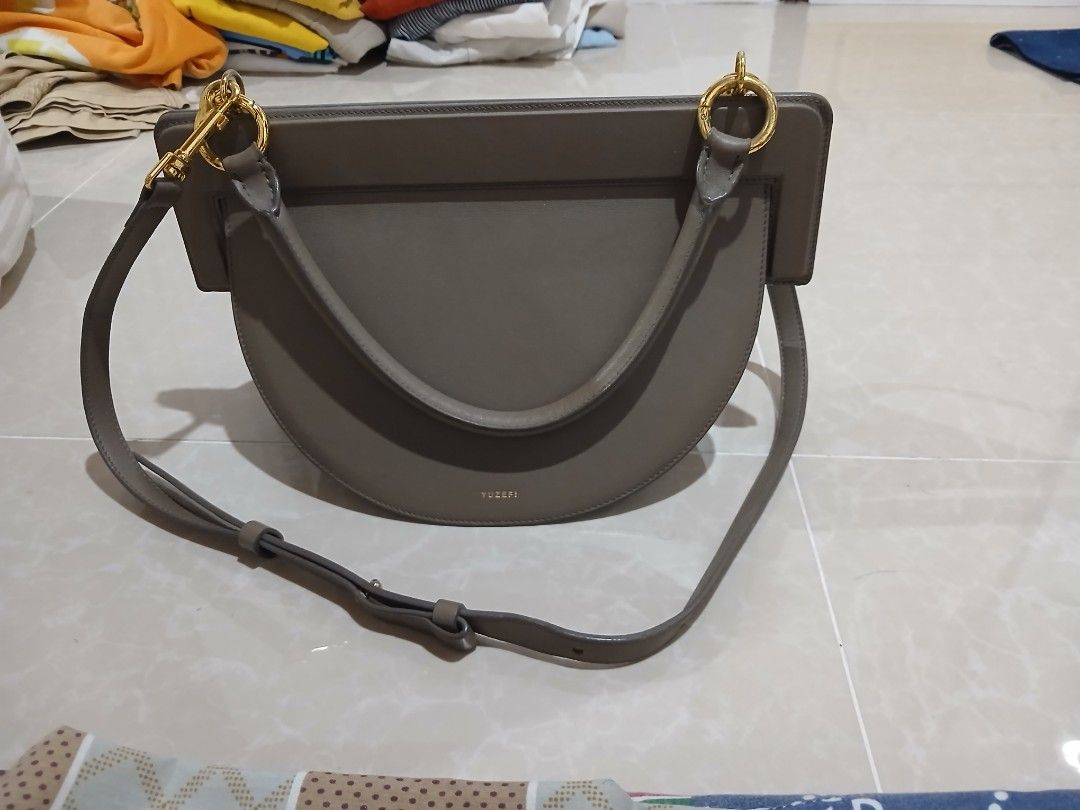 Yuzefi taupe leather shoulder bag (Category: Shoulder Bags) located in Quezon City. Submitted by mcenon35 (Listing ID 1466479317, Image 1). Description: - Brand: Yuzefi - Color: Taupe - Material: Premium leather - Style: Structured half-moon shoulder bag - Hardware: Gold-tone - Straps: Top handle and long adjustable strap - Origin: Made in Spain - Condition: Clean surface, sturdy construction.