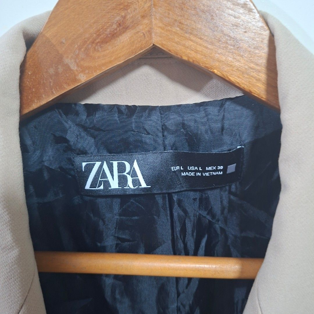 Zara Beige Double Breasted Blazer Size L (Category: Coats, Jackets and Outerwear) located in Quezon City. Submitted by arargarcia (Listing ID 1466460021, Image 2). Description: - Brand: Zara - Color: Beige - Size: L - Material/Origin: Made in Vietnam with clean, smooth fabric - Design: Double-breasted front with two black buttons - Details: Long sleeves, structured shoulders, and flap pockets on both sides - Lining: Black inner lining - Condition