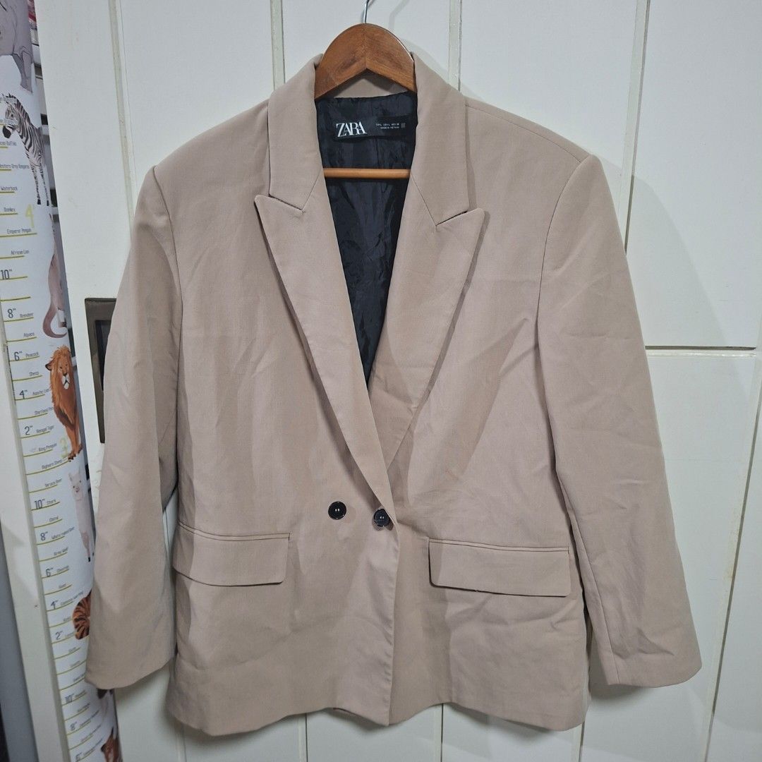 Zara Beige Double Breasted Blazer Size L (Category: Coats, Jackets and Outerwear) located in Quezon City. Submitted by arargarcia (Listing ID 1466460021, Image 1). Description: - Brand: Zara - Color: Beige - Size: L - Material/Origin: Made in Vietnam with clean, smooth fabric - Design: Double-breasted front with two black buttons - Details: Long sleeves, structured shoulders, and flap pockets on both sides - Lining: Black inner lining - Condition