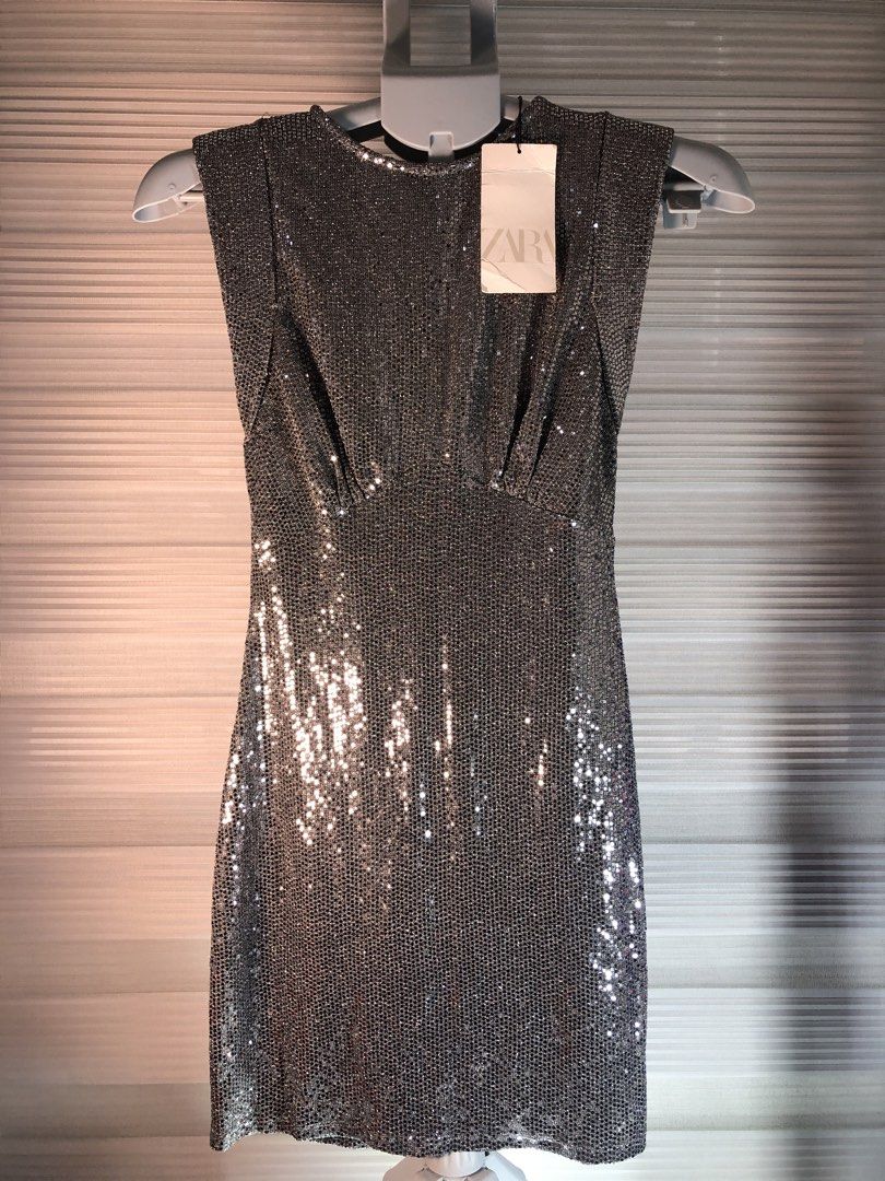 Zara Silver Glitter Metallic Mini Dress (Category: Dresses) located in Manila. Submitted by all.dressed.up (Listing ID 1466386279, Image 2). Description: Brand: Zara Style: Sleeveless mini dress with rounded neckline and keyhole back button Color/Finish: Eye-catching silver glitter Fit: Fitted silhouette with subtle waist pleating Details: Fully lined interior, original retail tags attached Size: S Condition: Brand new WYSIWYG Strictly no return/